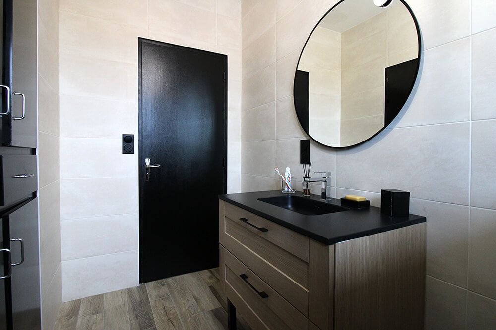 Une salle de bain à la porte noir fermée.