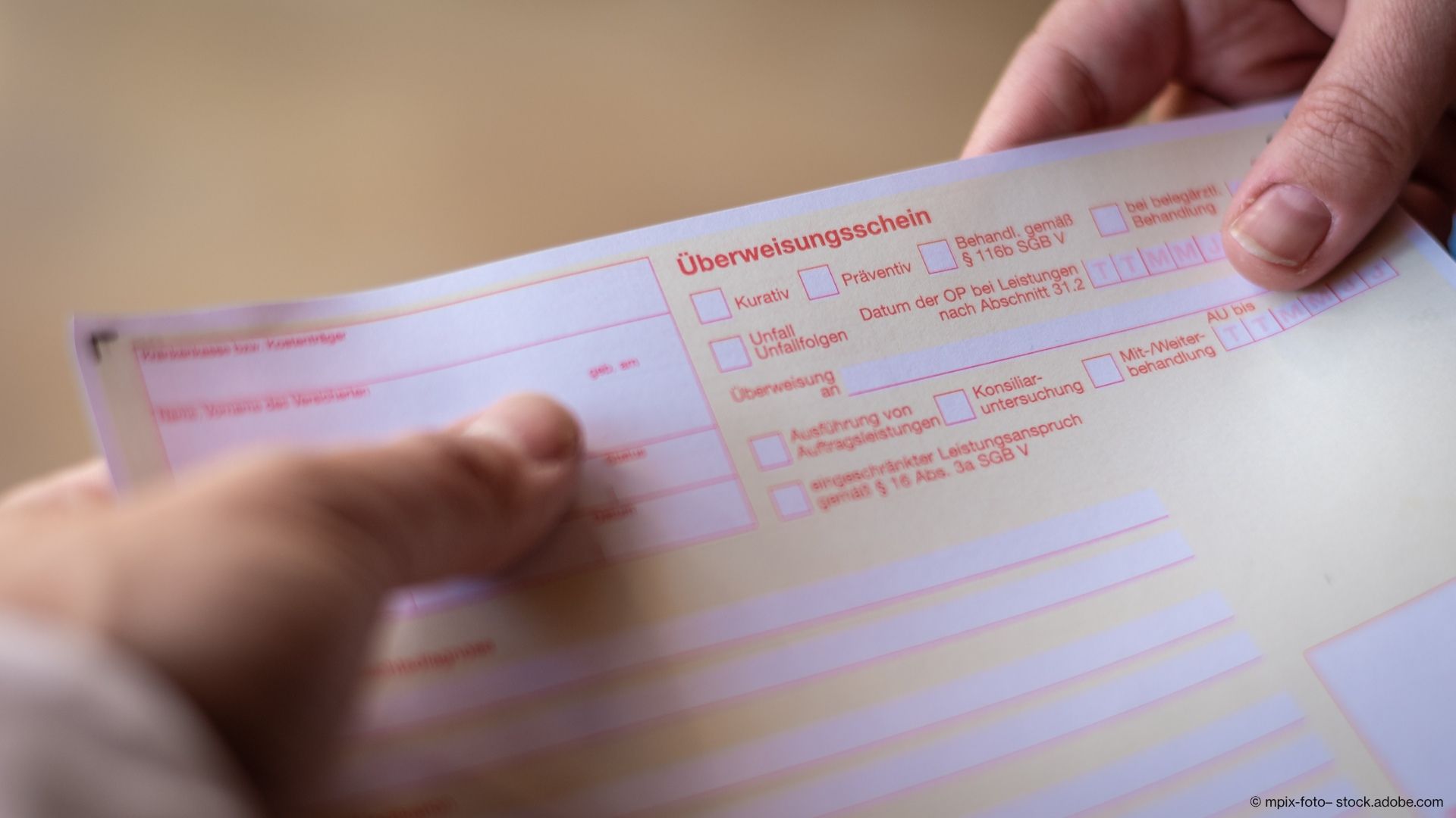 Person hält Überweisungschein