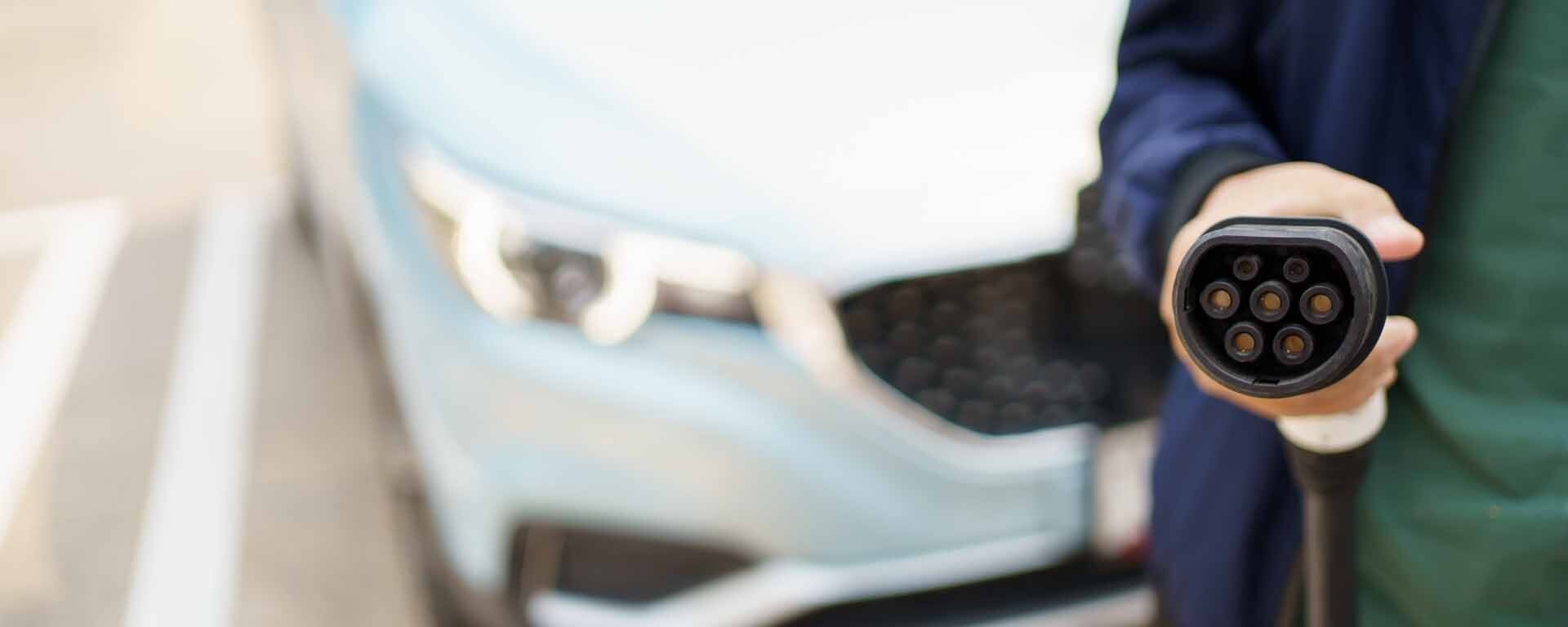 Technicien tenant un chargeur de voiture électrique