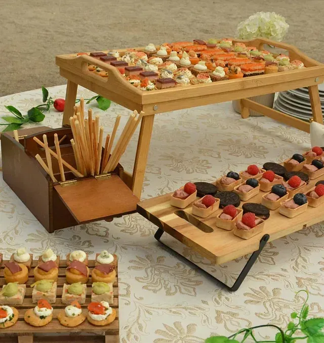 Dos bandejas de madera llenas de comida están sobre una mesa.