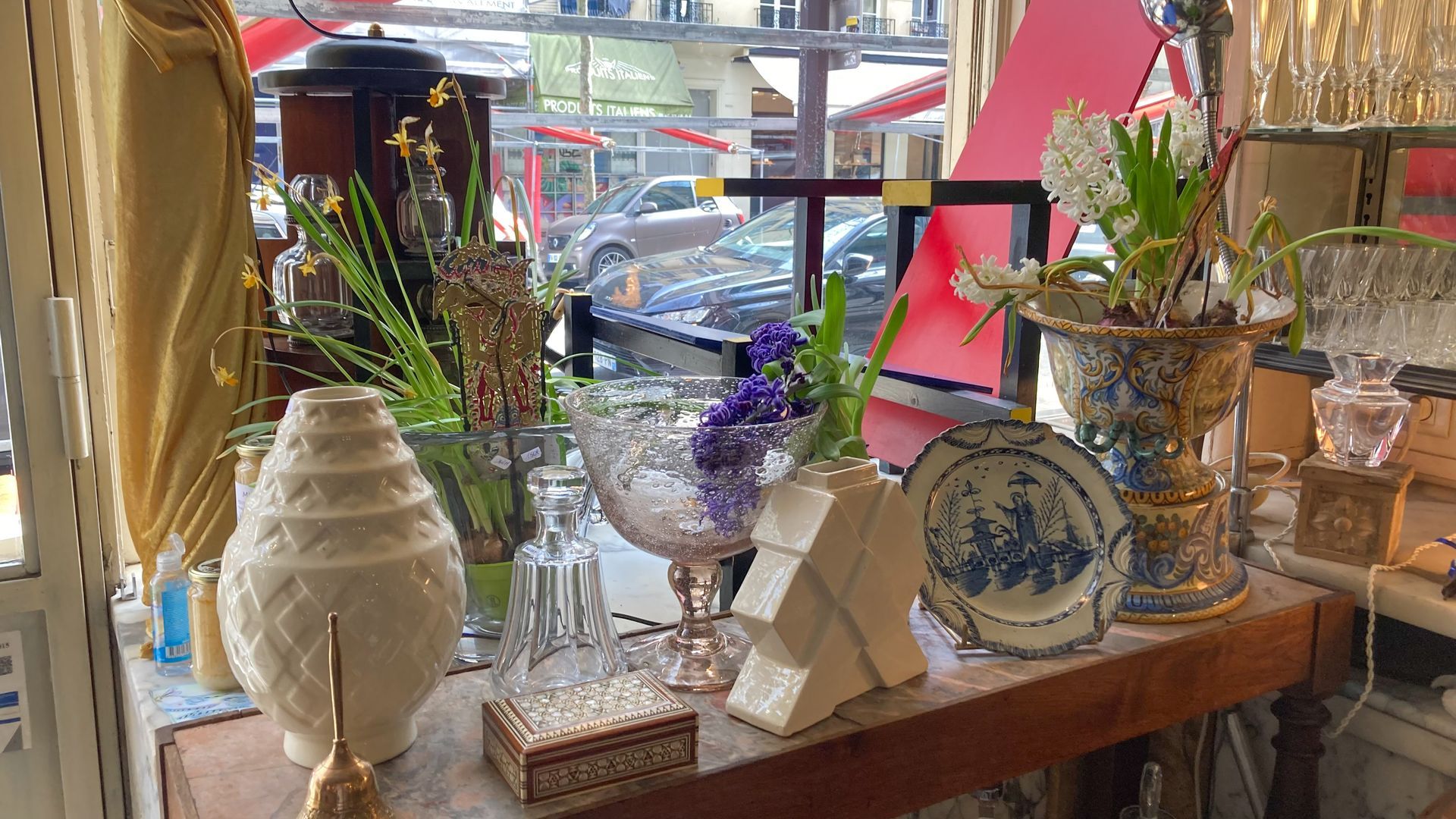 Table en bois avec des vases et autres objets anciens exposés.