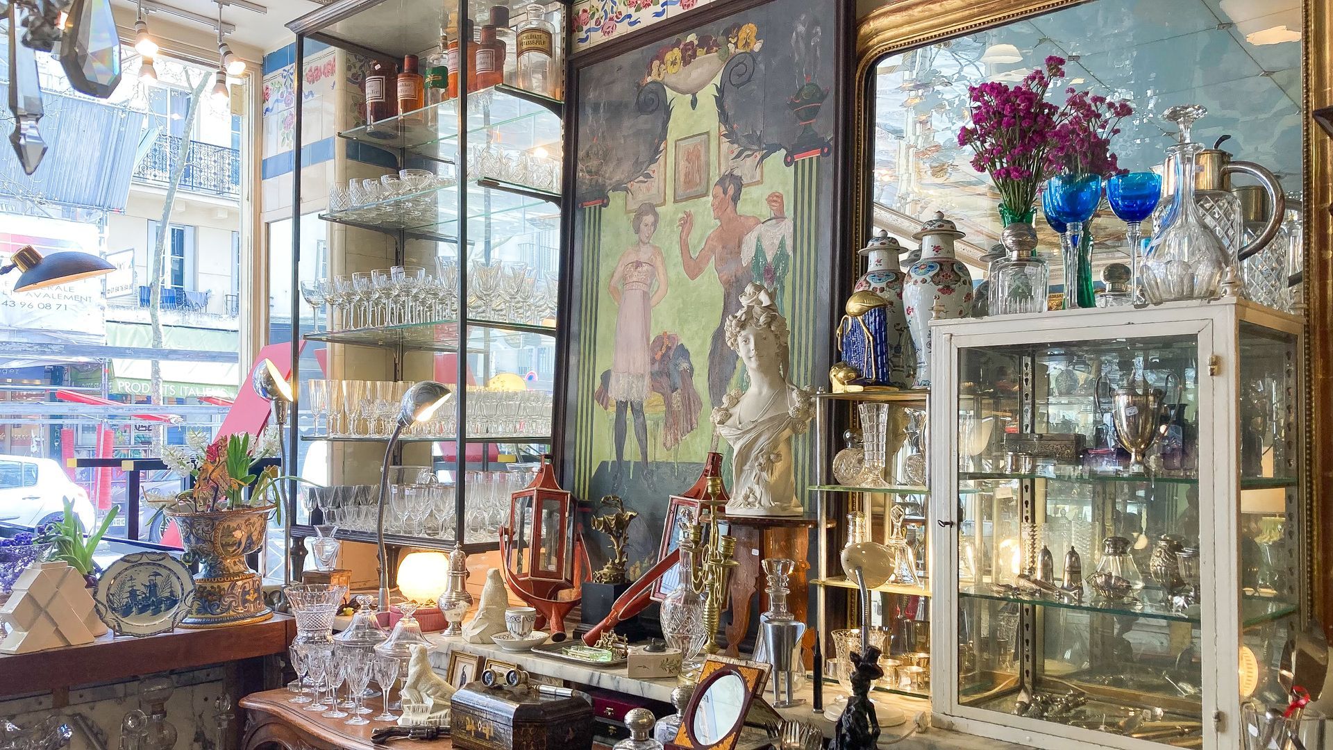 Mur d'exposition avec plusieurs étagères et tables exposants des objets, de l'argenterie, etc.