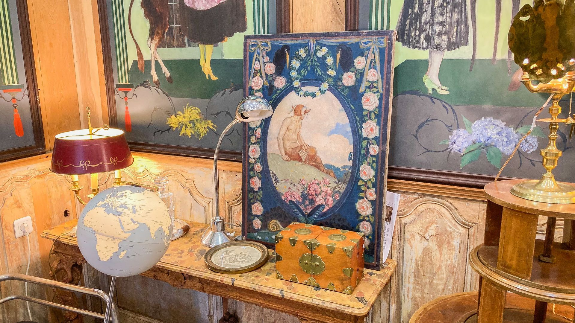 Petit coffre orange, tableau bleu, globe, lampe rouge...