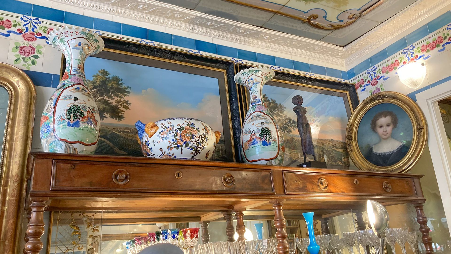 Table en bois avec des tiroirs, deux grands vases sont posés dessus.