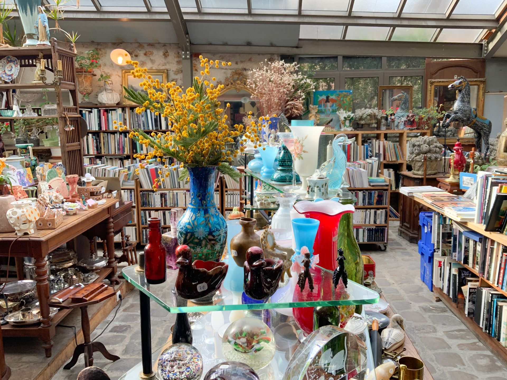 Table basse en verre avec des vases, des sculptures de canards…