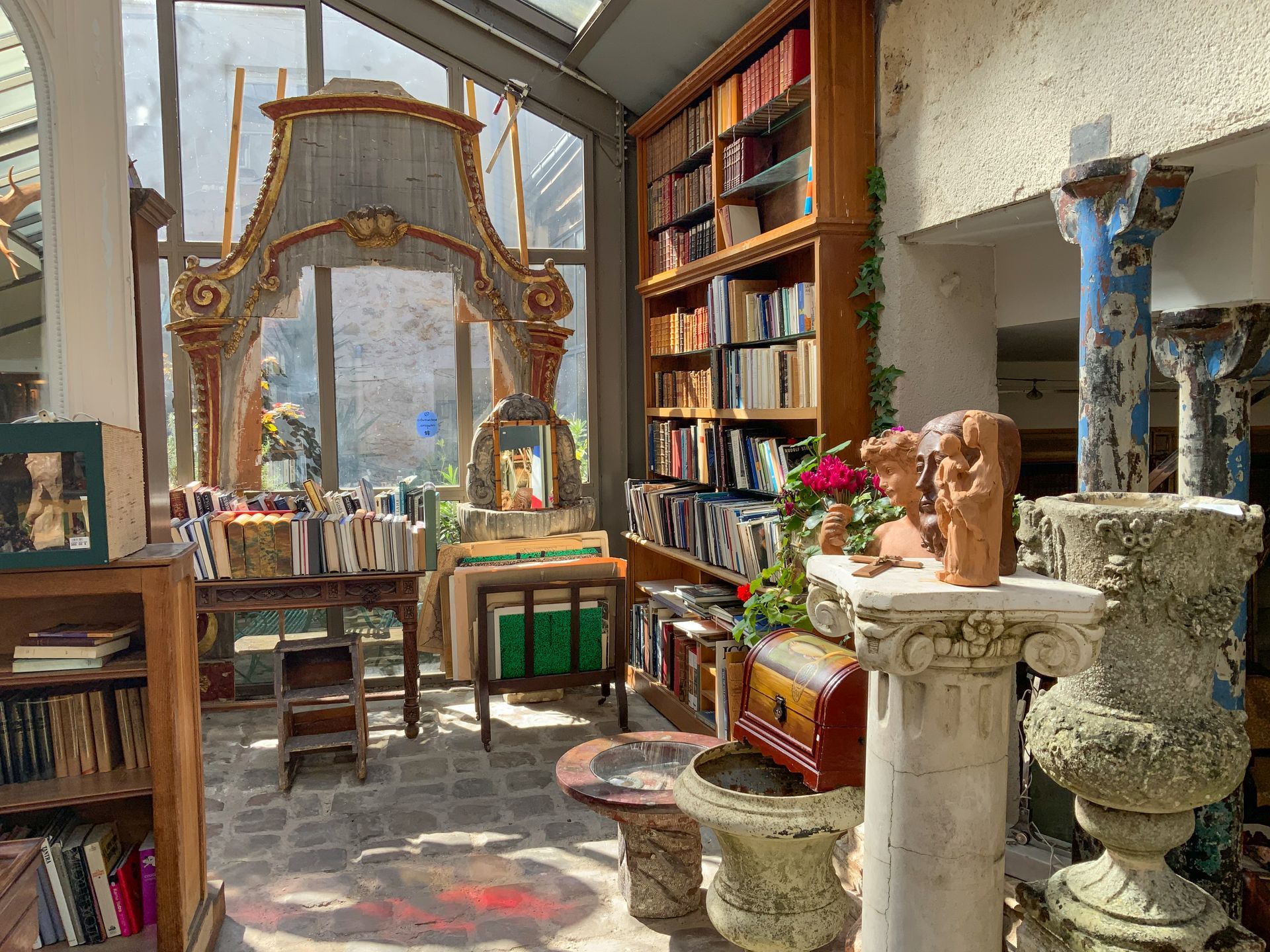 Entrée d'une salle d'exposition avec des sculptures en pierre, une bibliothèque…