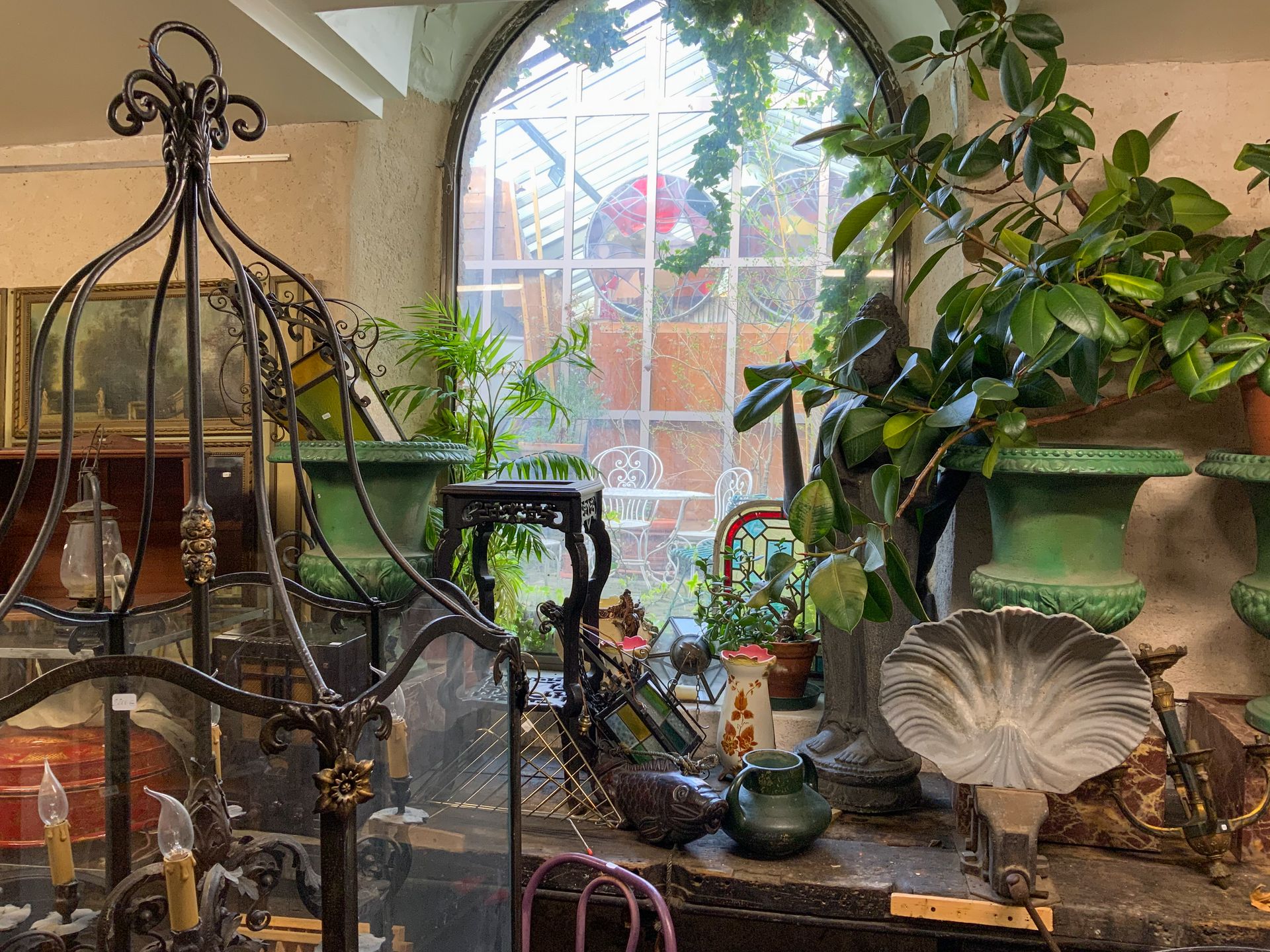 Diverses sculptures et objets posés près d'une plante verte.