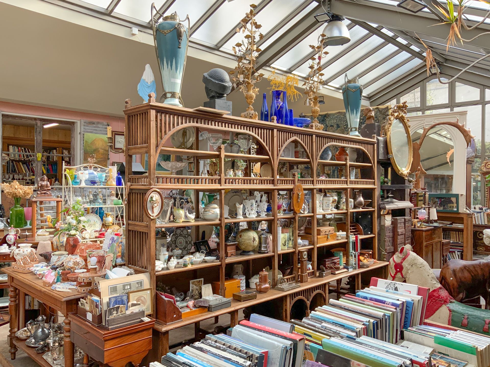 Grande pièce avec des objets anciens exposés : sculptures, livres, bibelots…