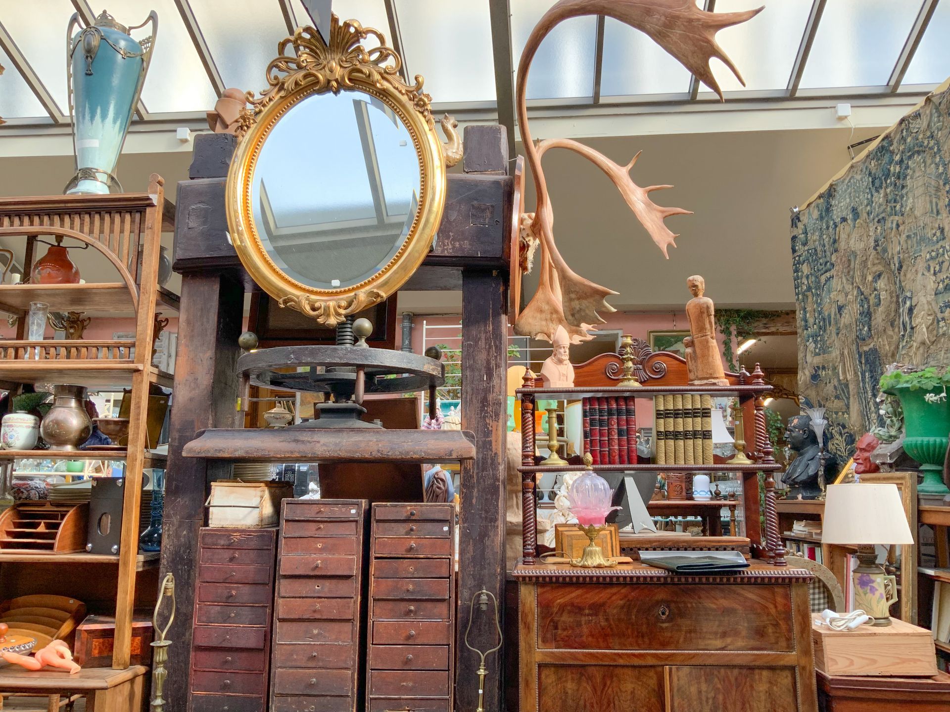 Anciens meubles en bois avec un miroir ovale au-dessus.