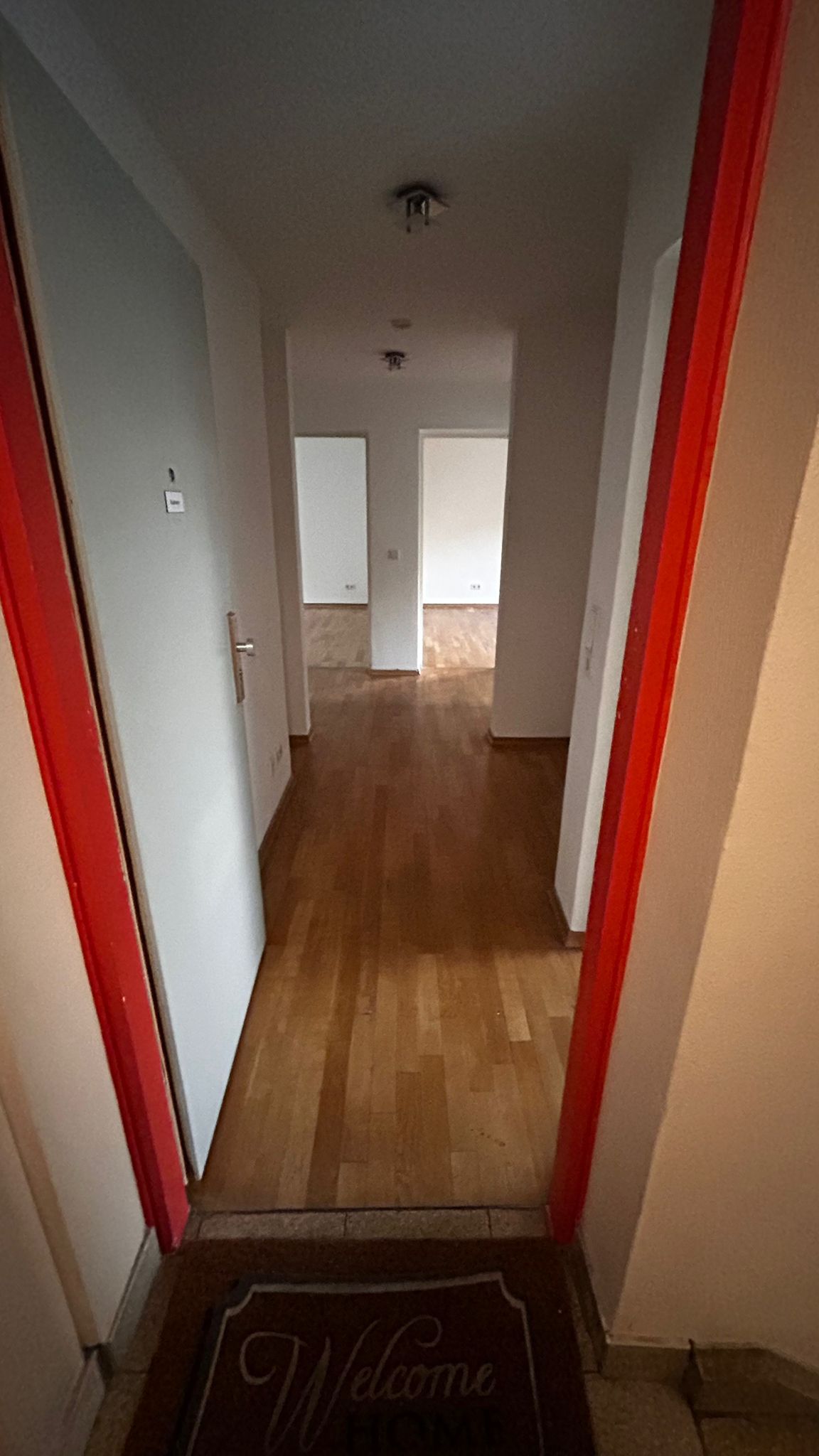 Blick durch einen Flur mit zwei an der Decke montierten Lampen.