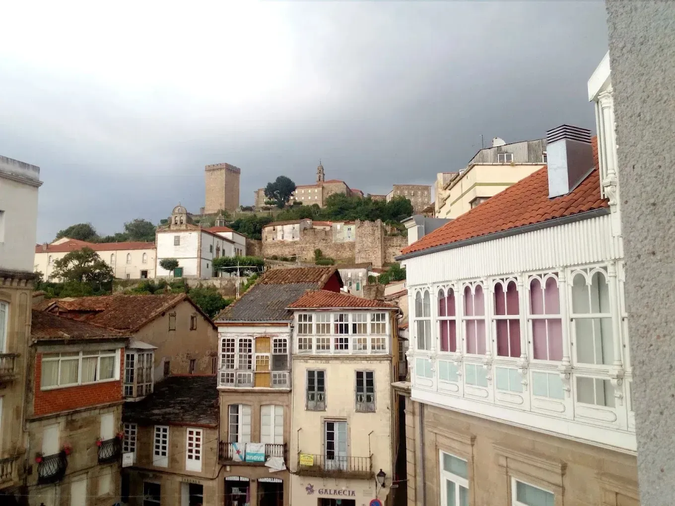 Vista de una ciudad europea con techos de tejas rojas, balcones blancos 