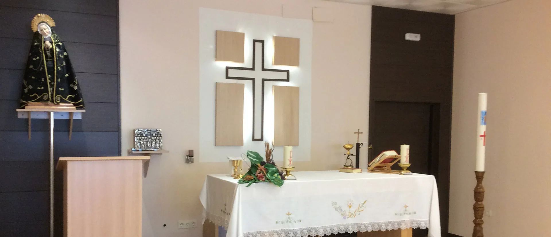 Una iglesia con una cruz en la pared y una estatua de Jesús.