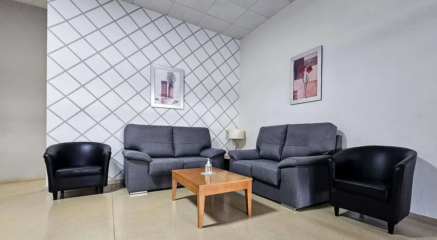 Una sala de estar con un sofá, sillas y una mesa de café.