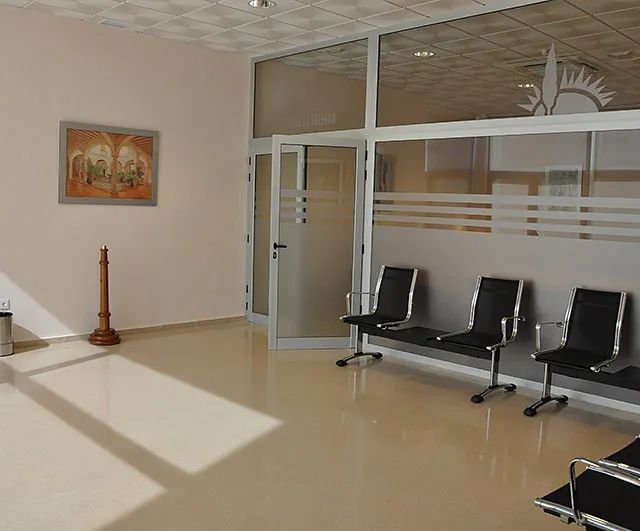 Una sala de espera con sillas y un cuadro en la pared.