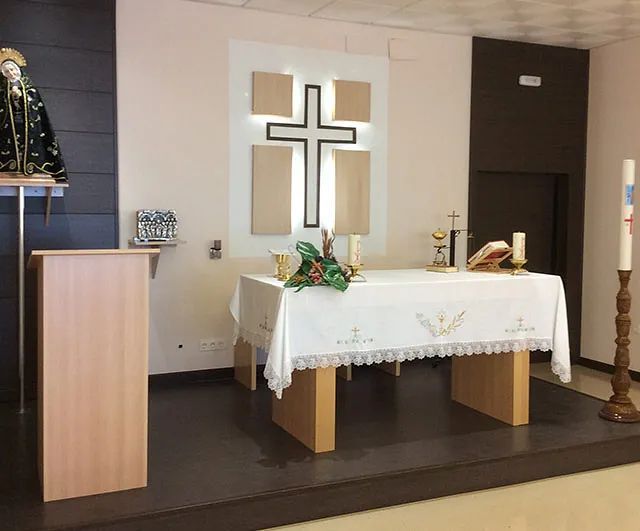 Un altar en una iglesia con una cruz en la pared