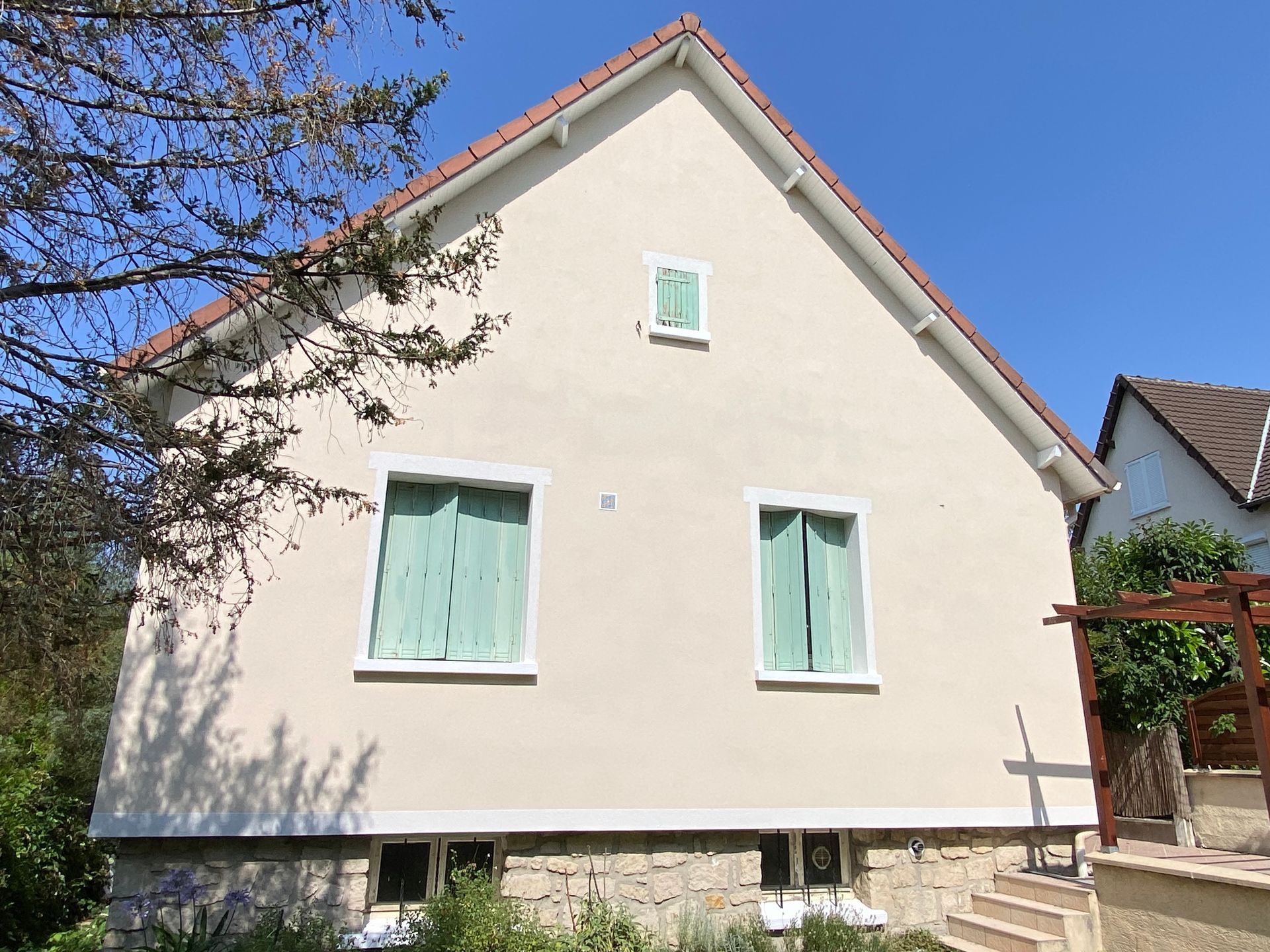 Façade d'une maison aux volets verts