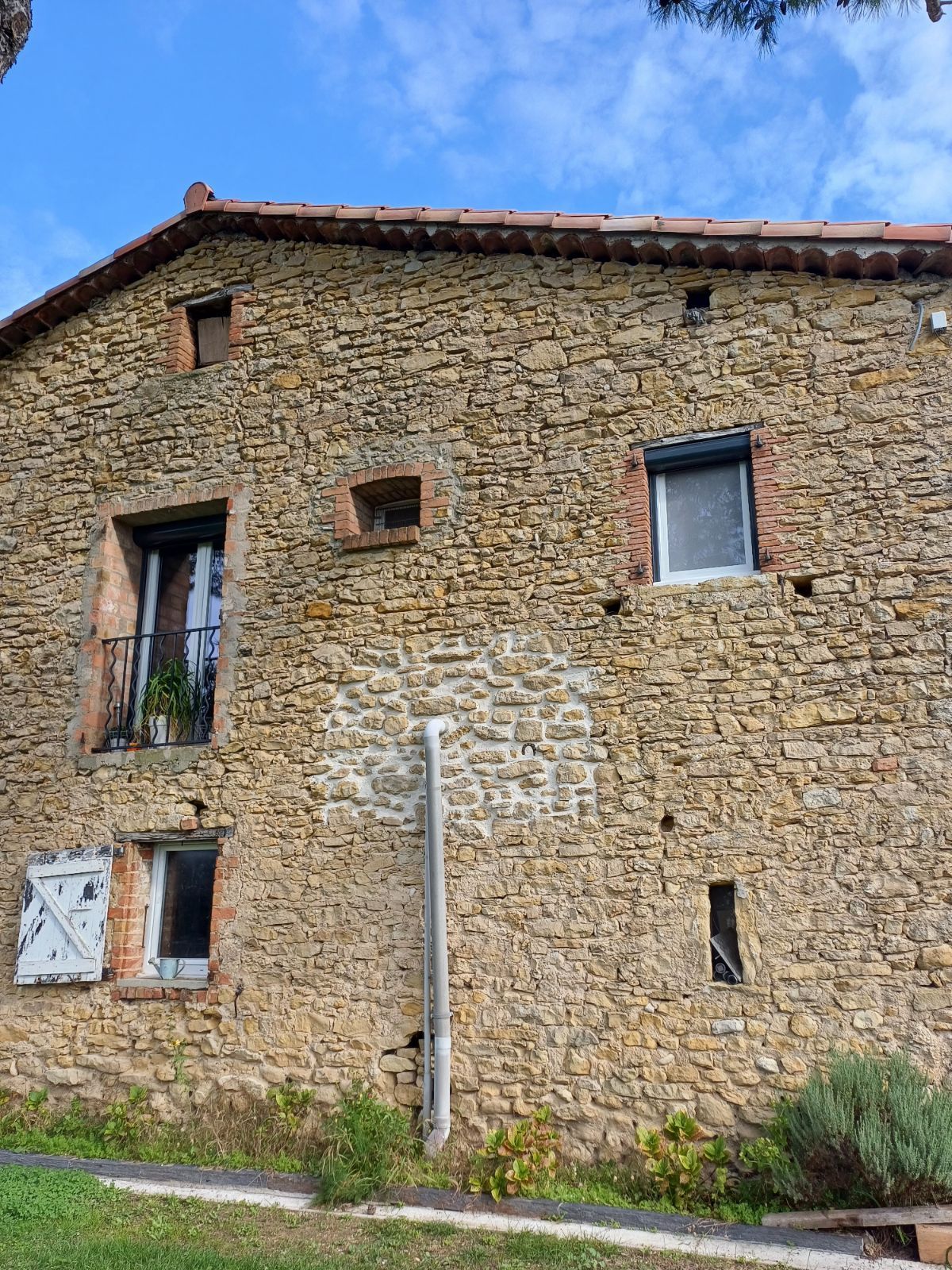 Bâtiment avec toit en ardoise, murs en pierre, échafaudage