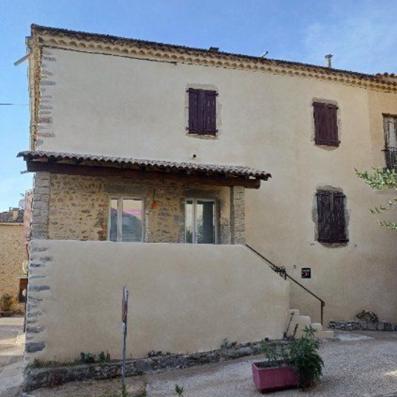 Un homme sur un échafaudage répare le mur extérieur d'un bâtiment