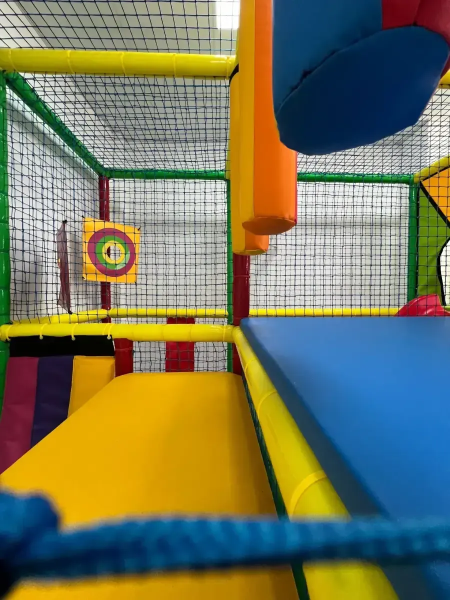 Parque infantil interior con obstáculos de espuma de colores y juego de objetivos.