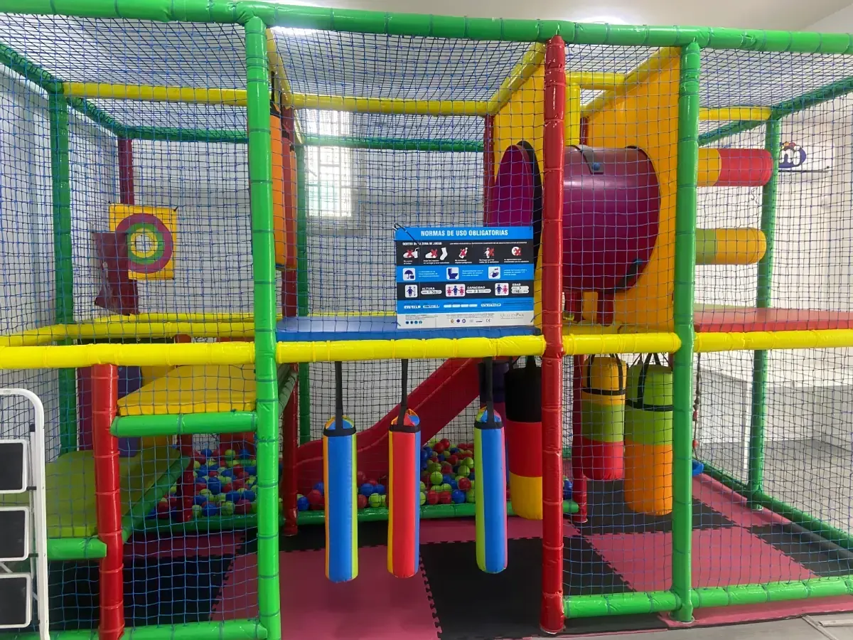 Parque infantil interior con obstáculos de espuma de colores y juego de objetivos.