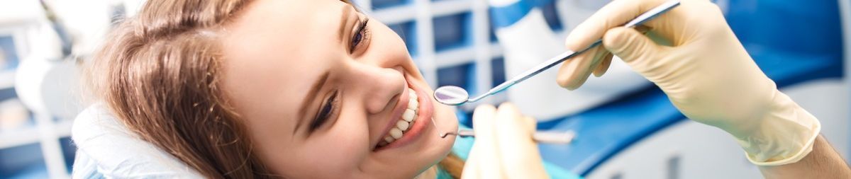 Una mujer se hace examinar los dientes por un dentista.