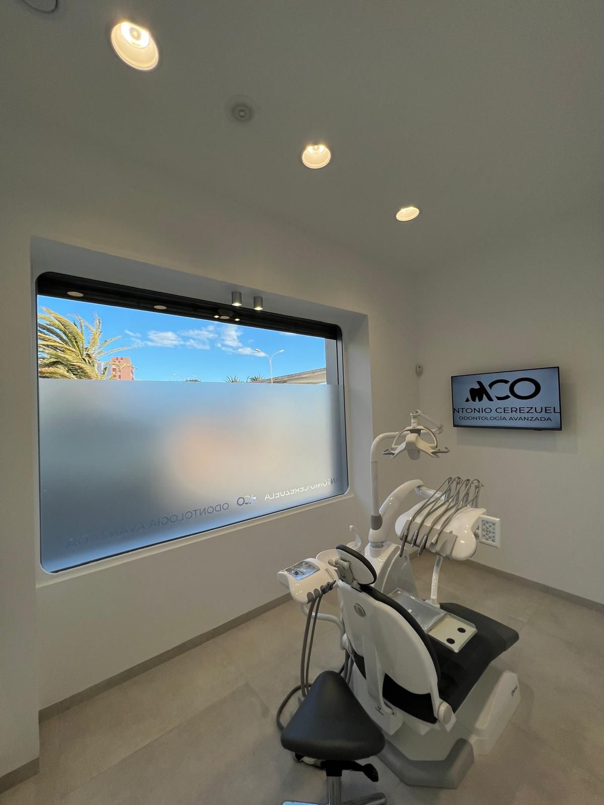 Un consultorio dental con un sillón dental y una ventana.