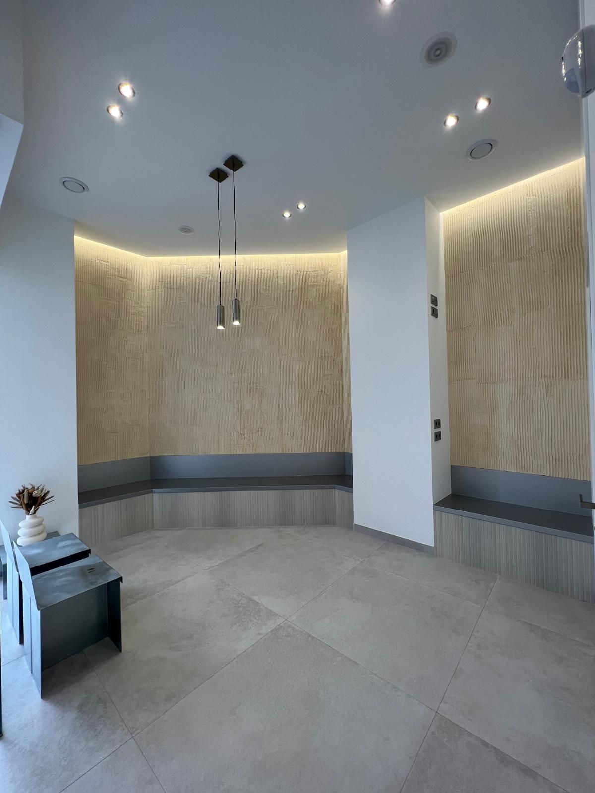 Una sala de espera con un banco y una mesa en ella.