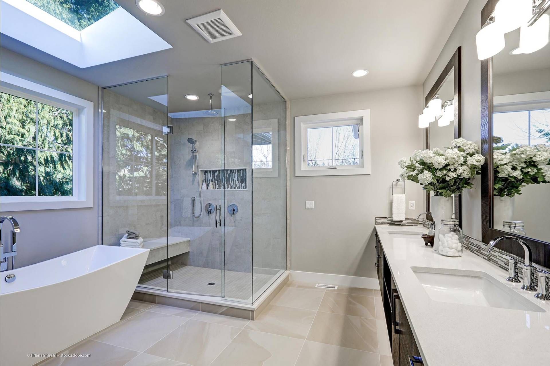 modern eingerichtetes Badezimmer mit hellen Fliesen und Badewanne