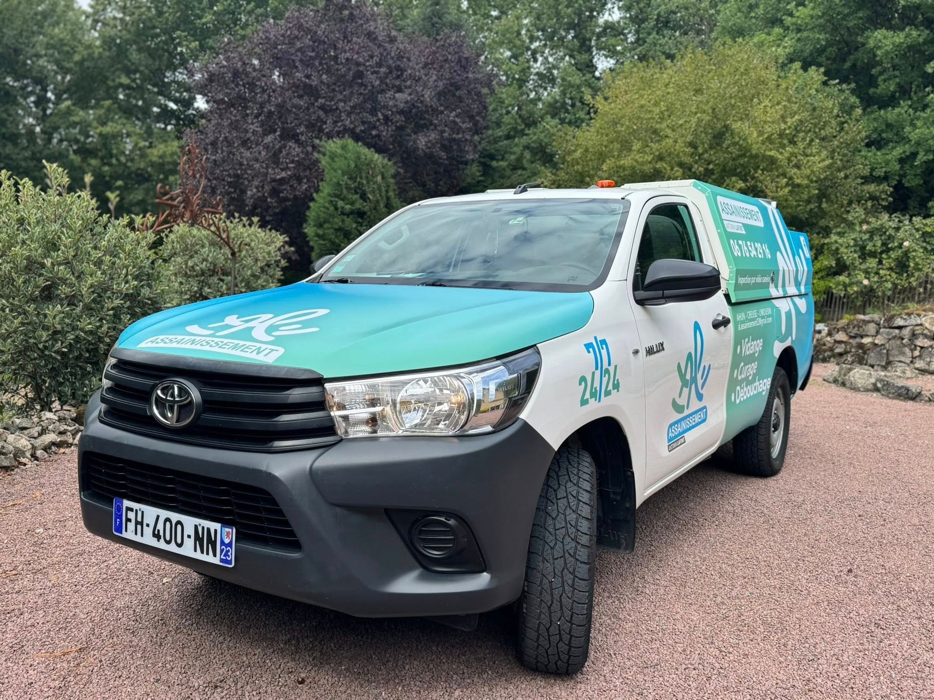 Camionnette recouverte d'un film turquoise et blanc.