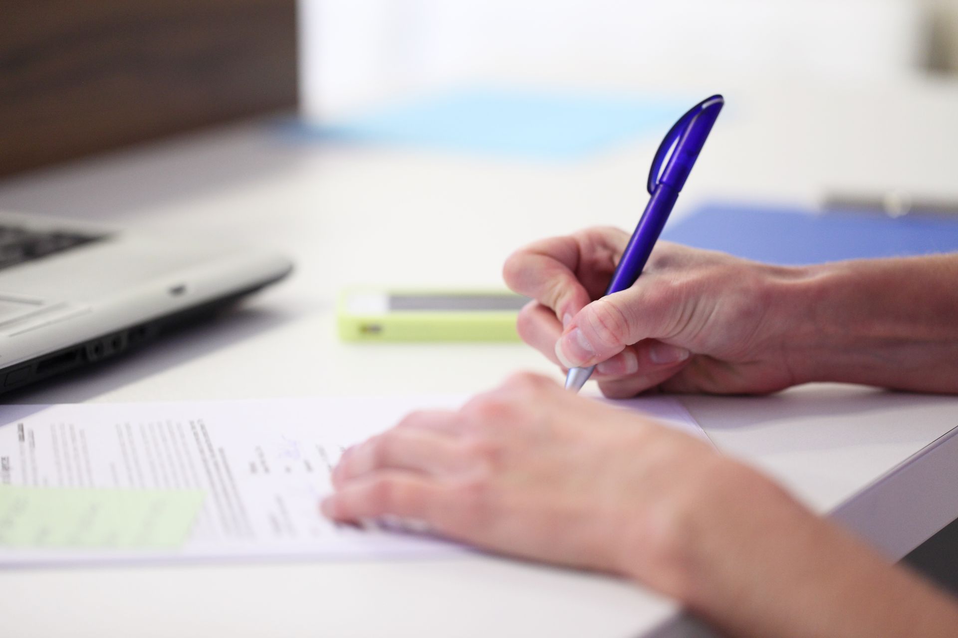 Une personne écrit avec un stylo violet.