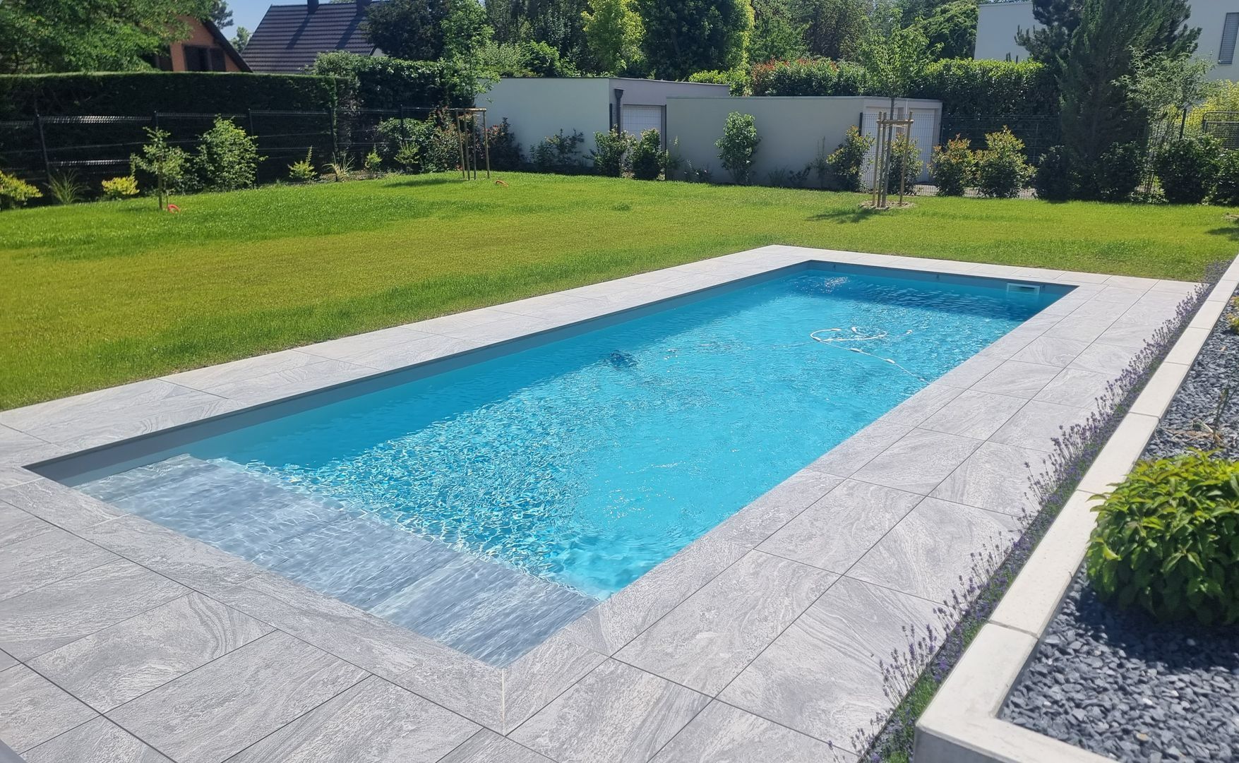 Piscine creusée et terrasse en carrelage