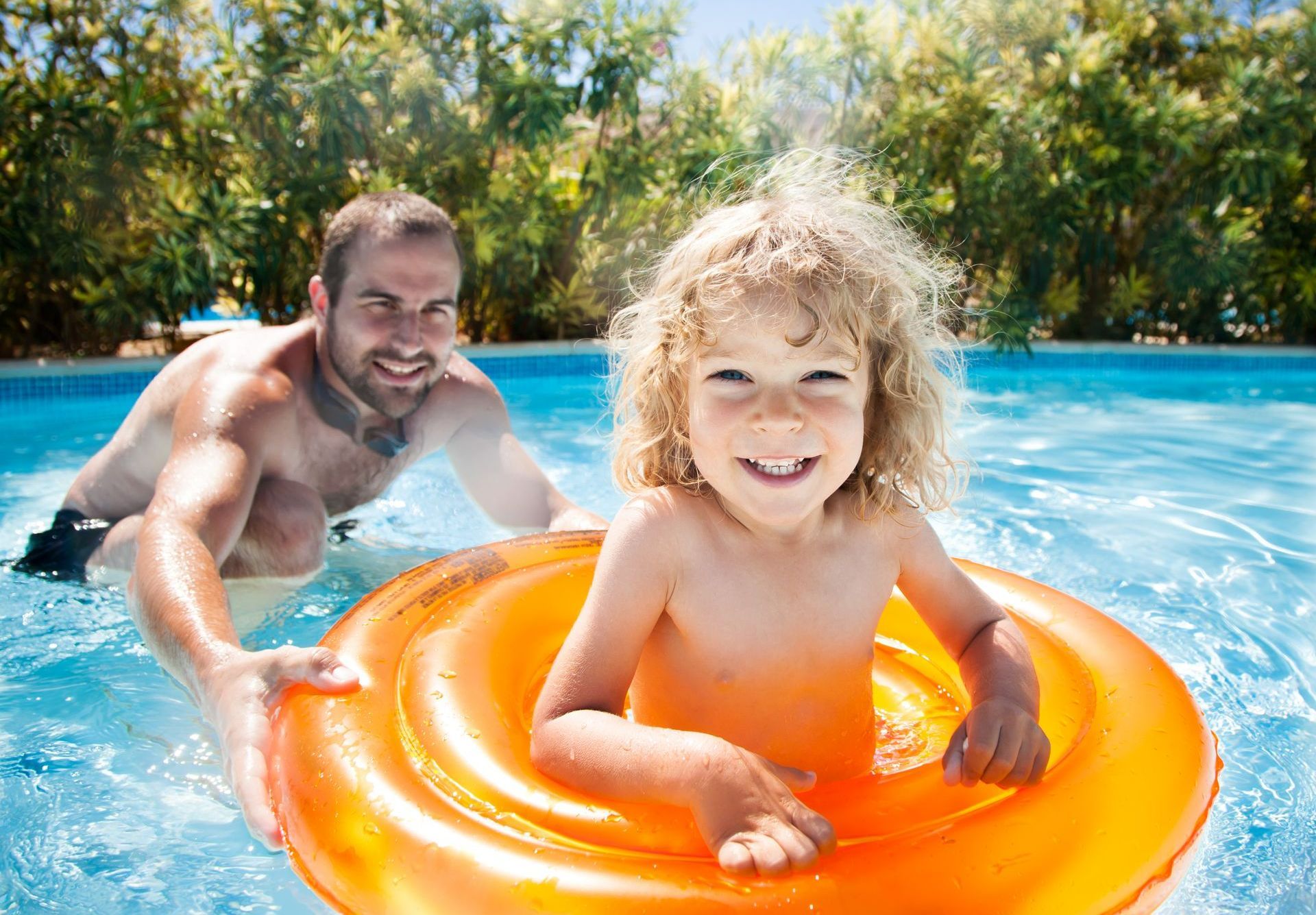 Un enfant et son père dans une piscine