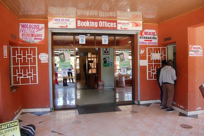 Banking offices entrance with red walls, glass doors, and a man standing by the right doorway