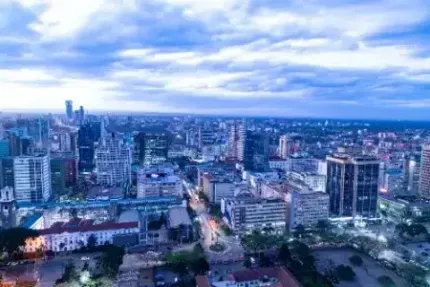 City skyline under dramatic cloudy sky, with tall buildings above a low urban foreground.