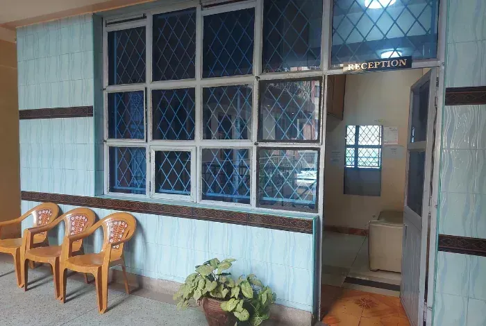Porch with blue windows, wooden chairs, potted plant, and an open doorway to a room