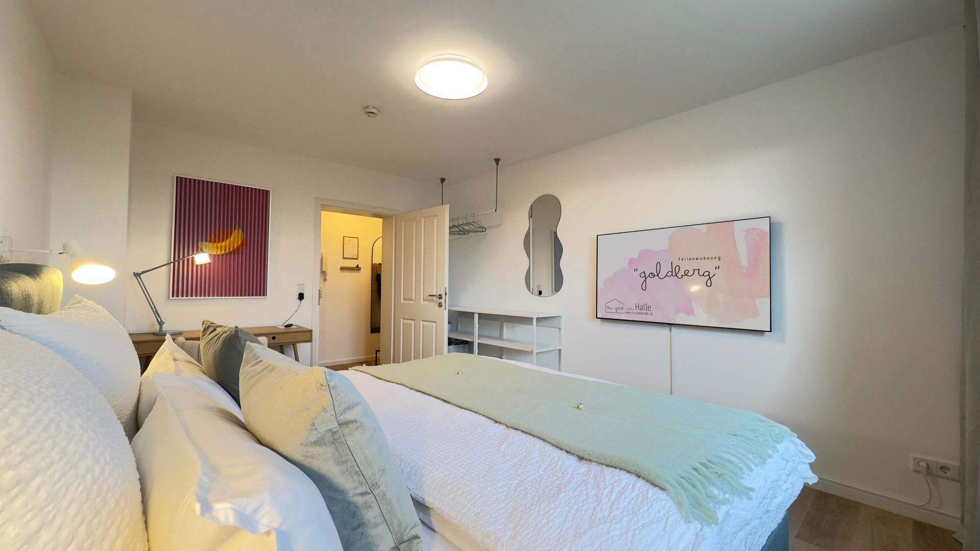 Boxspringmatratze mit TV-Blick und Regale für Kleidung im Elternschlafzimmer