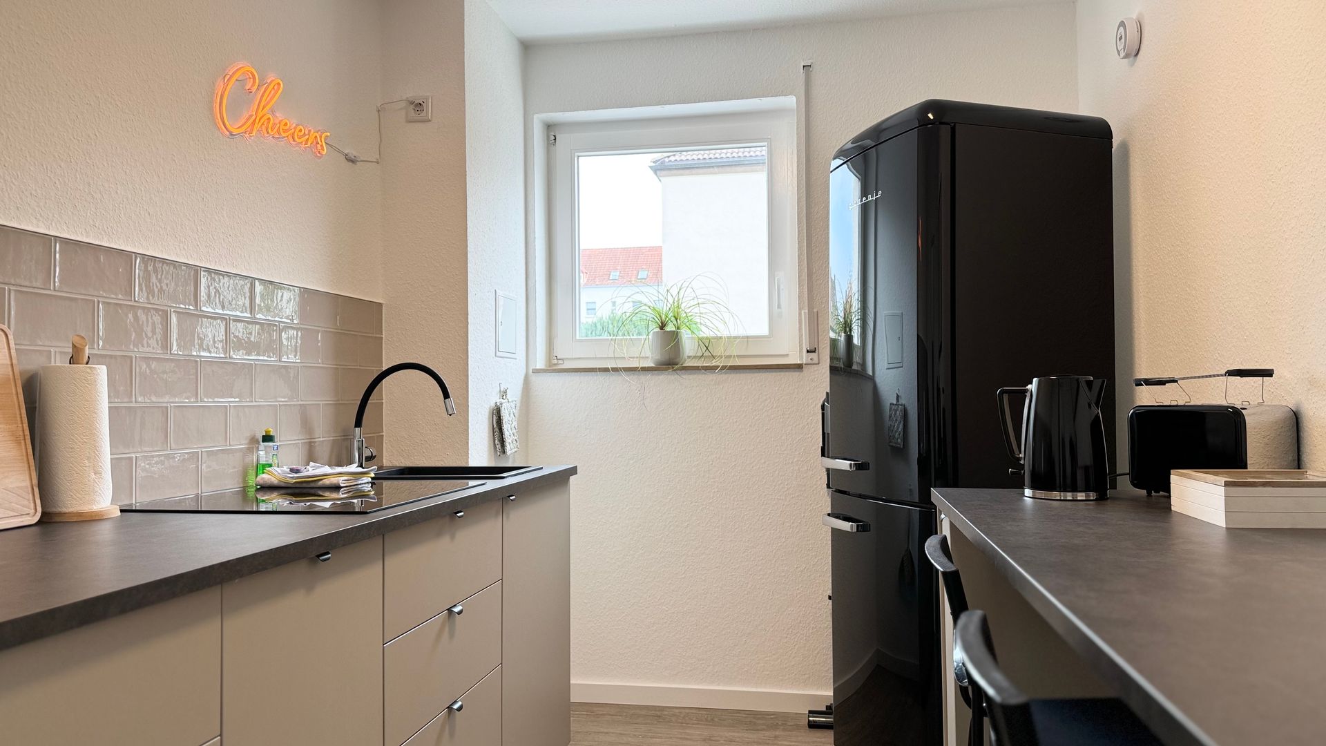 Kücheneingang mit Fenster und Kühl-/Gefrierkombination in schwarz