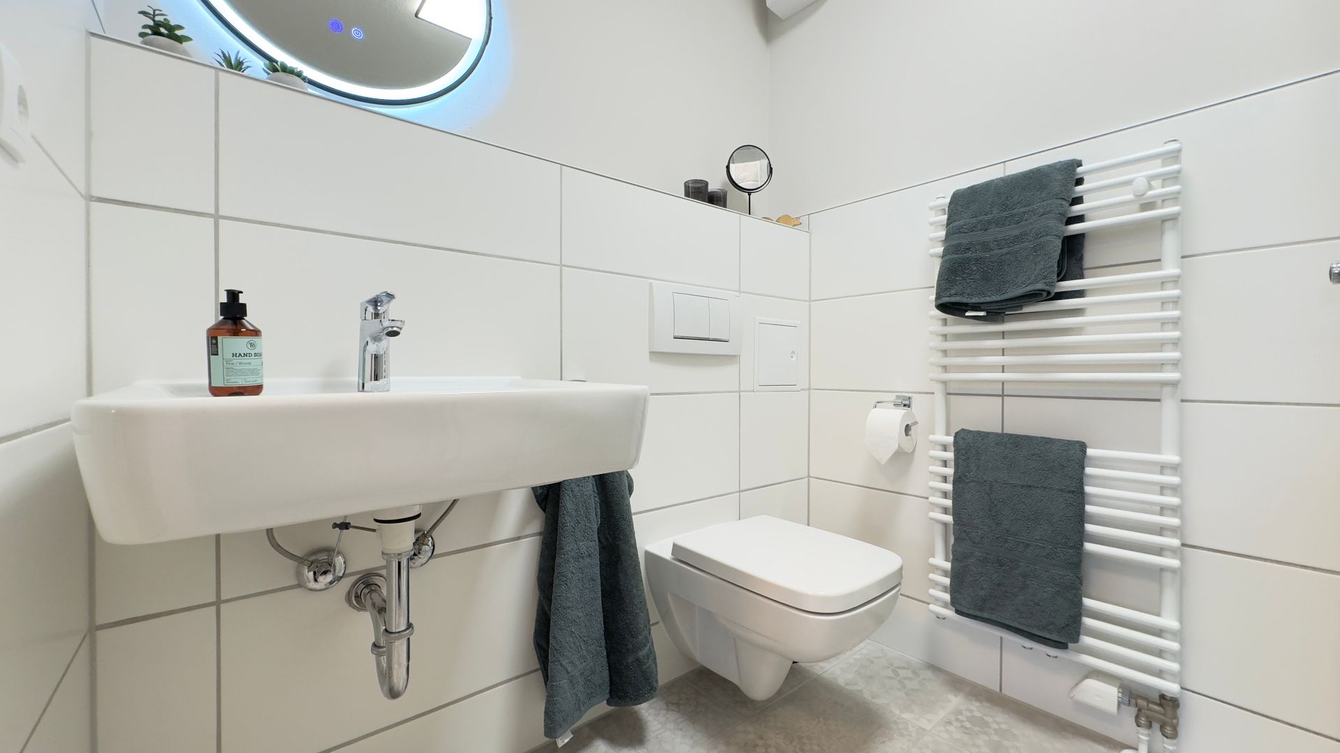 Modernes Badezimmer mit Waschbecken und Spiegel in der Ferienwohnung Am Park