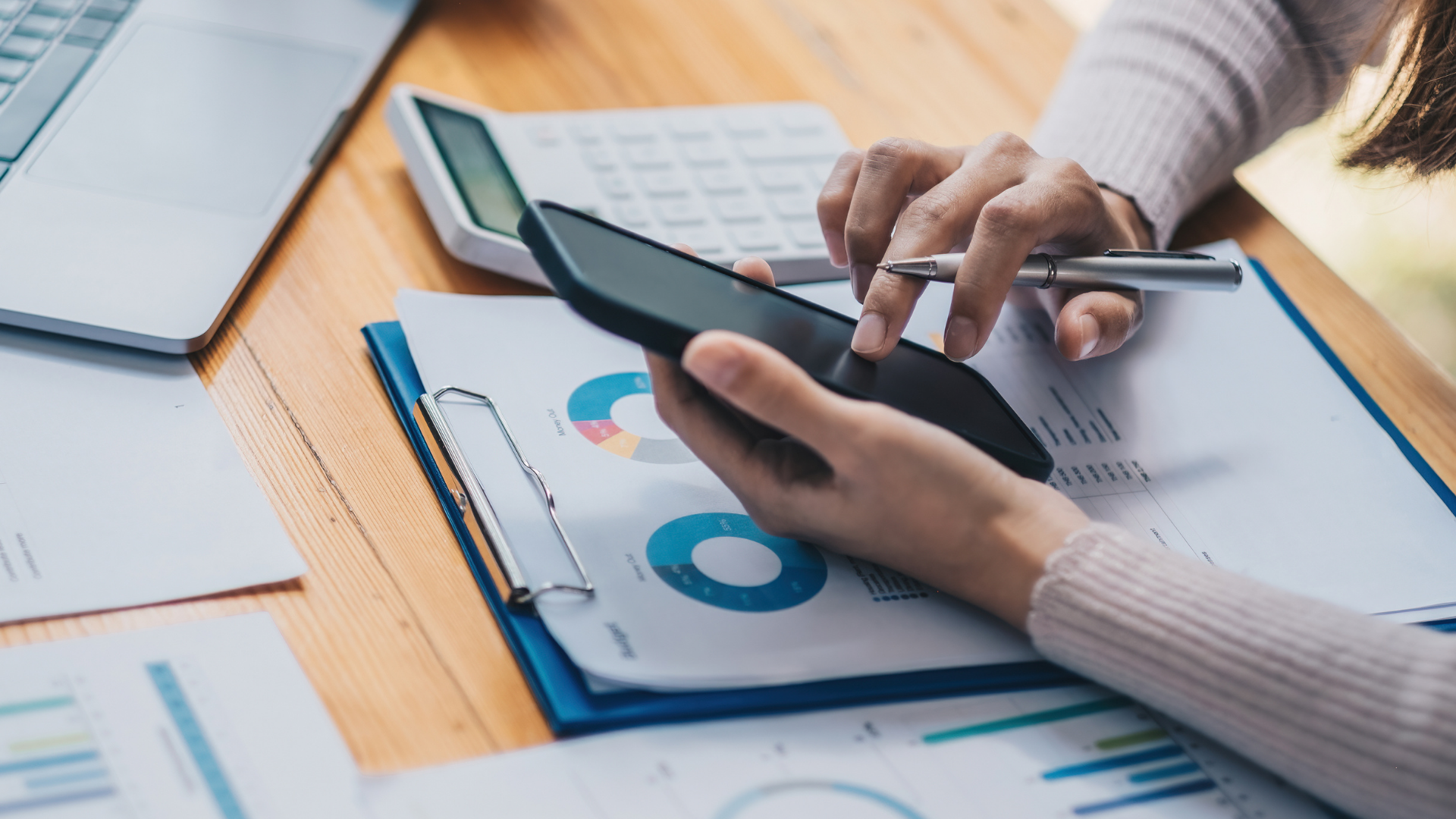 Une personne utilise une tablette et un stylet pour consulter des rapports financiers.