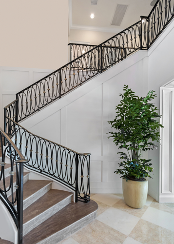 Un escalier avec une rampe en fer forgé et une plante en pot