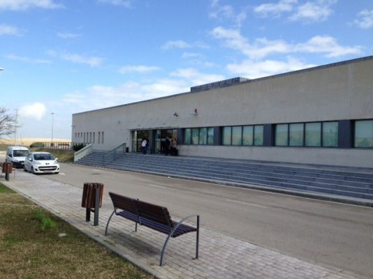 Un edificio con escaleras y un banco delante.