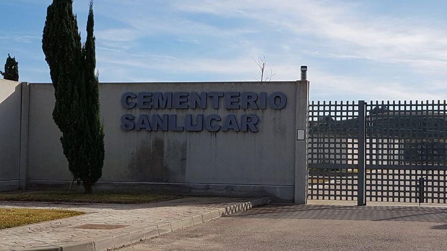 La entrada a un cementerio con una valla y un cartel que dice cementerio sanlucar.