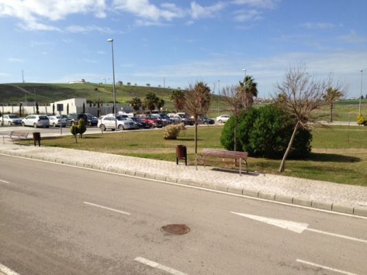 Un parque con muchos coches aparcados al costado de la carretera