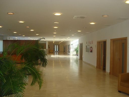 Un largo pasillo con un extintor en la pared.