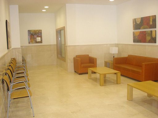 Una sala de estar con un sofá, sillas y una mesa de café.