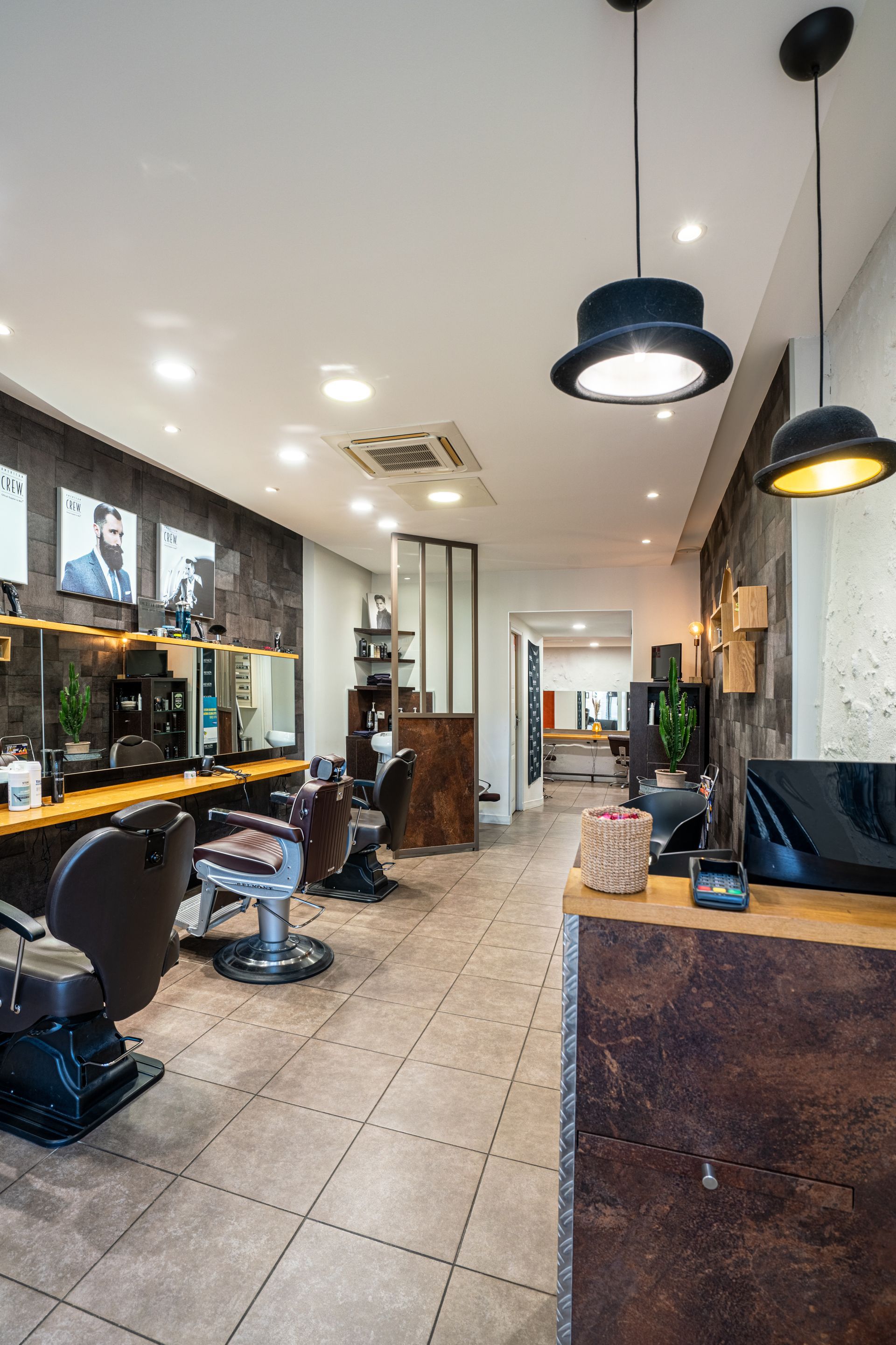 Comptoir du salon homme, fauteuils et posters affichés au mur