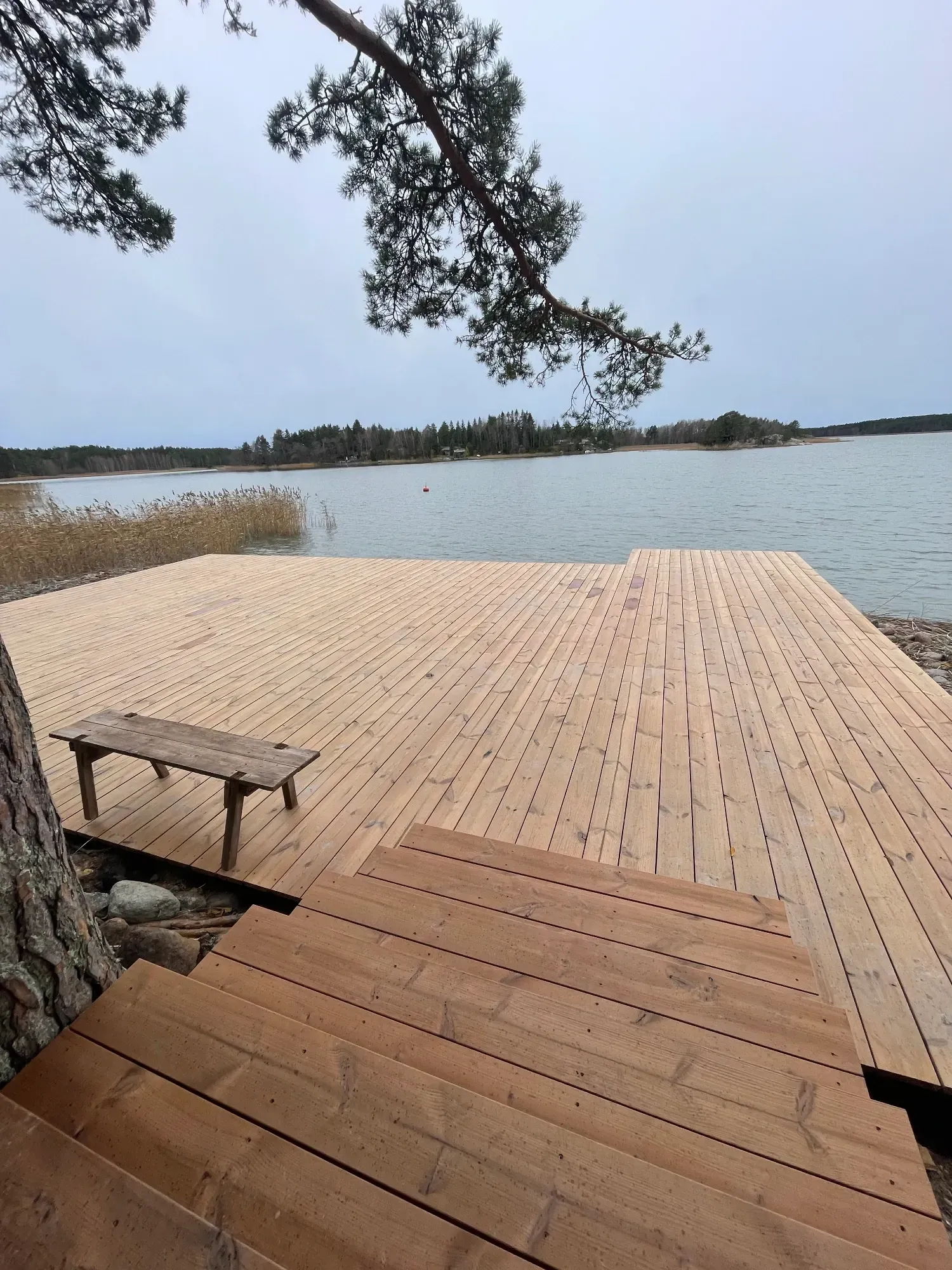 Massiivinen lehtikuusiterassi ja tukevat portaat rantaan Nauvon saaristossa.