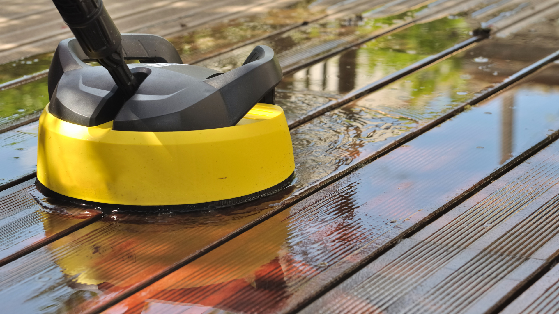 Nettoyage d'une terrasse en bois mouillée au nettoyeur haute pression.