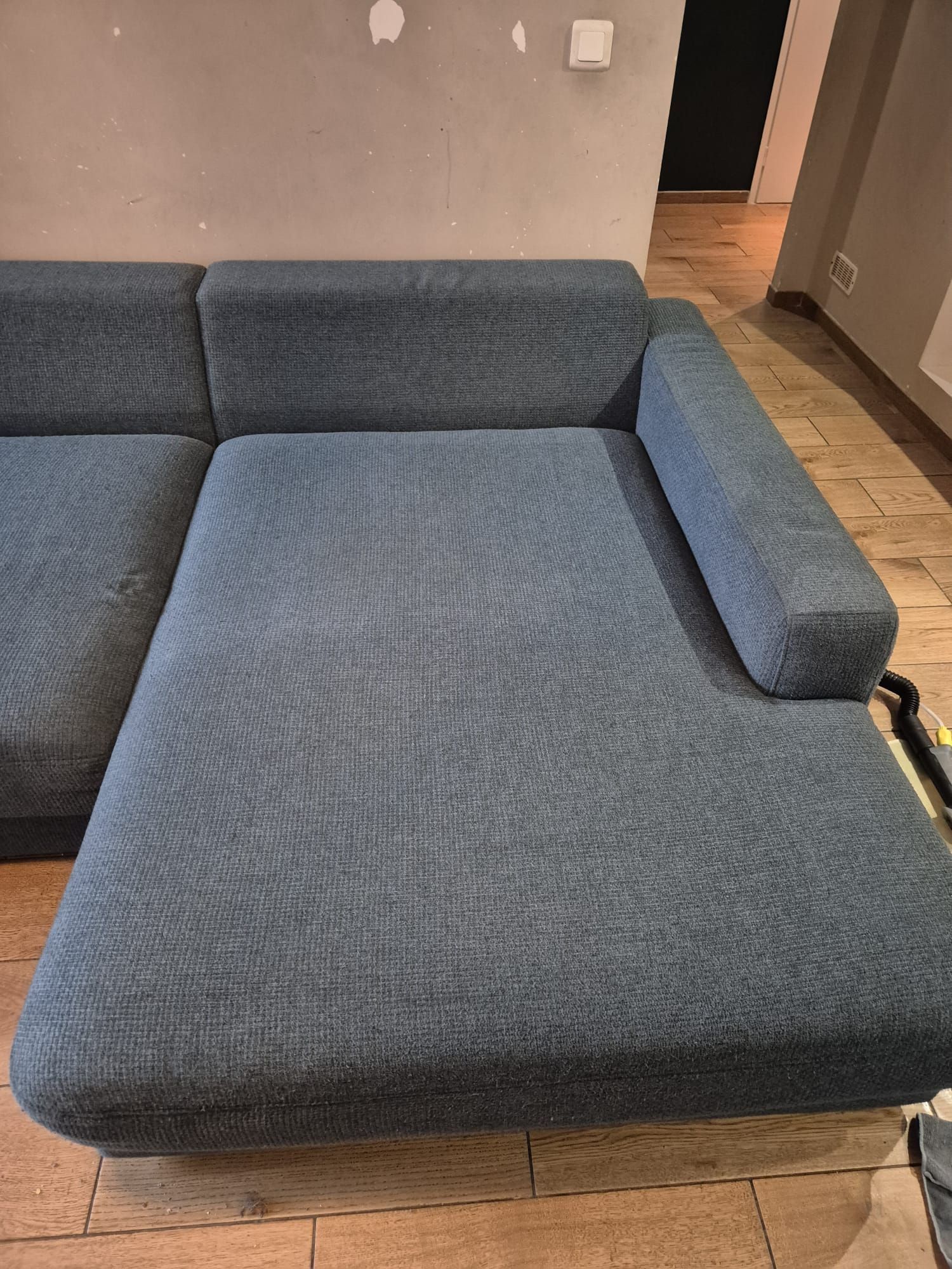 Matelas blanc sur un plancher en bois, contre un mur de couleur claire.