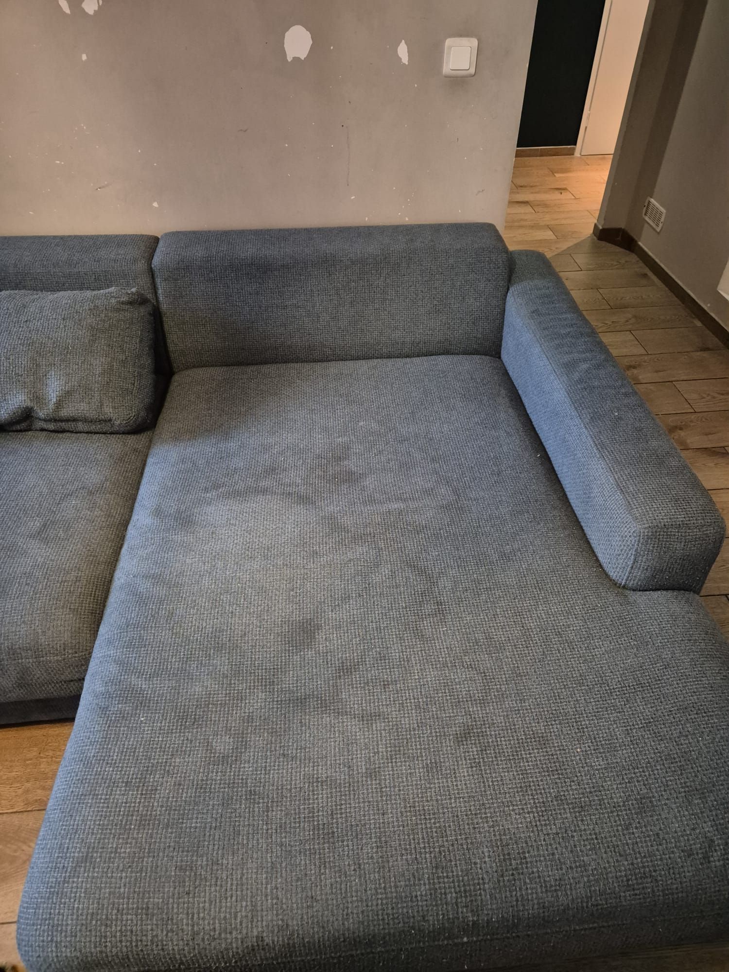 Matelas blanc taché de taches jaunes/brunes sur un plancher en bois.